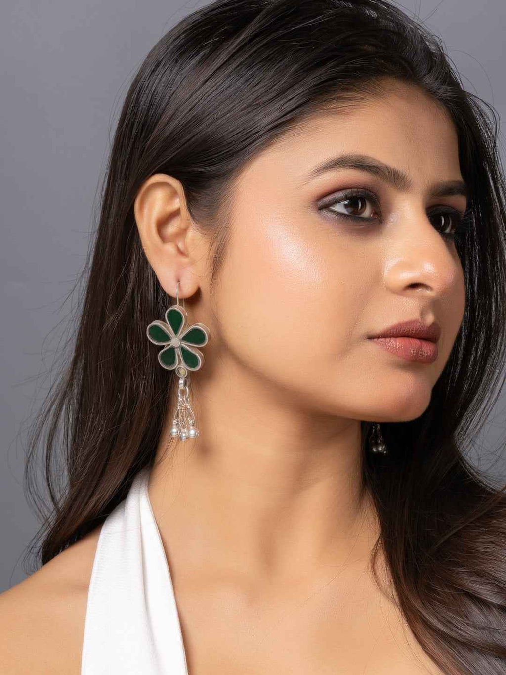 Elegant afghani earrings featuring green enamel flower design with dangling silver accents