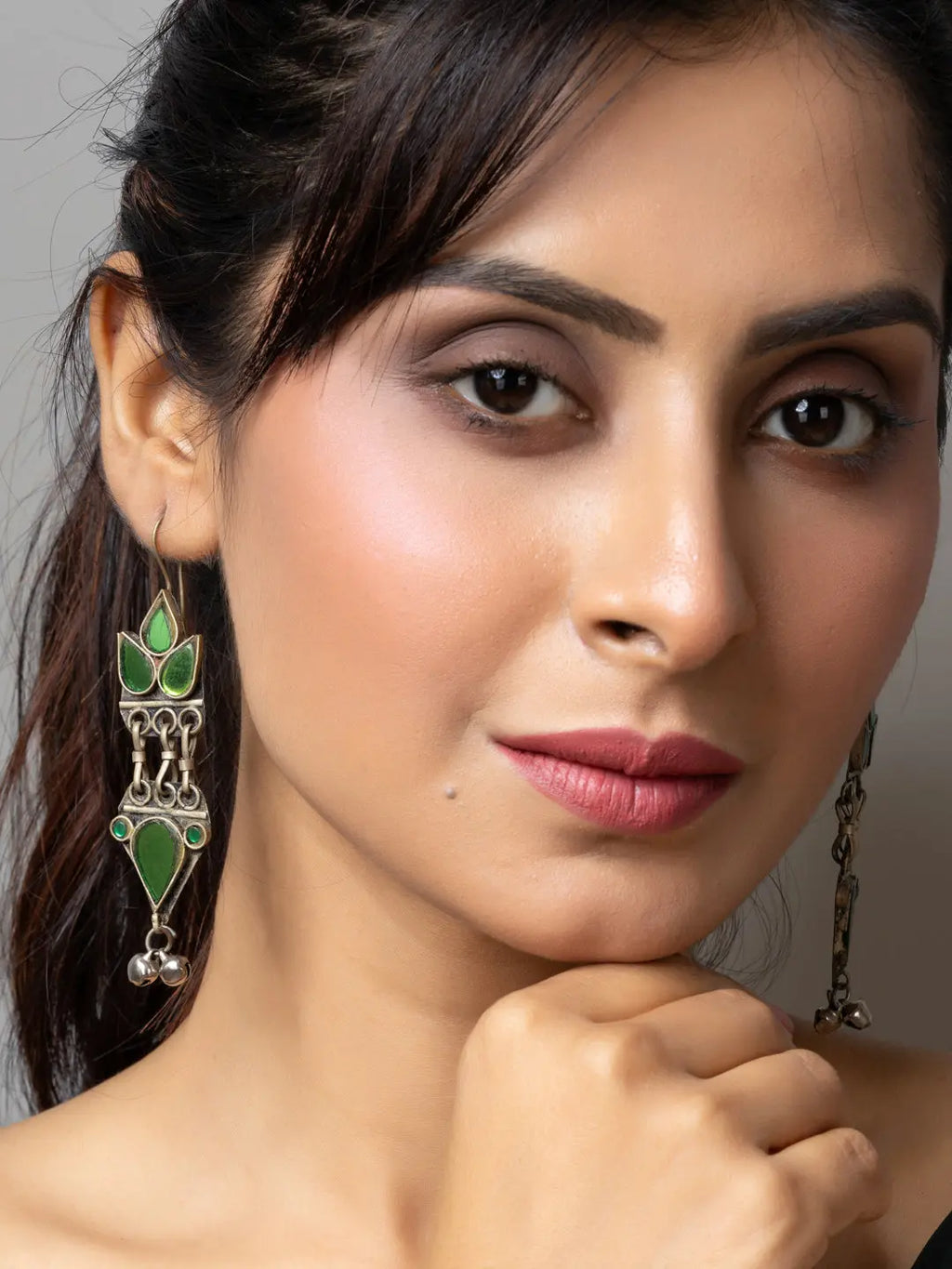 Close-up of woman wearing green and silver afghani earrings with intricate design by LOOK AND ADORN