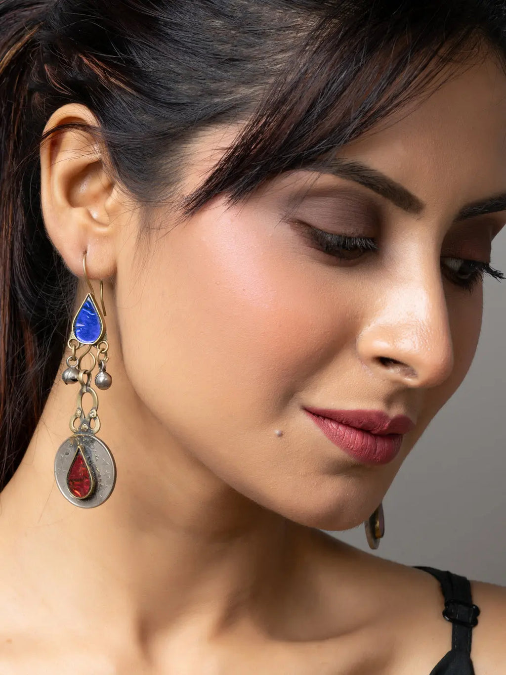 Elegant Afghani earrings with blue and red stones worn by a woman showcasing traditional Afghani jewellery