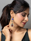 Woman wearing handcrafted afghani earrings with blue and red accents from LOOK AND ADORN