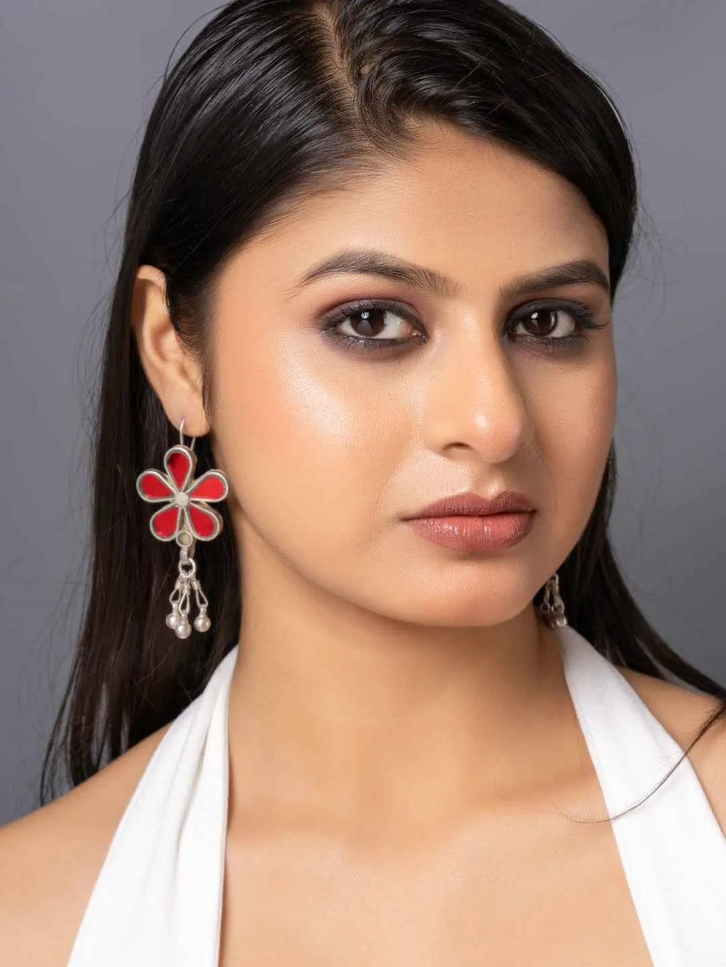 Colorful red and silver Afghani earrings featuring a floral design with dangling embellishments