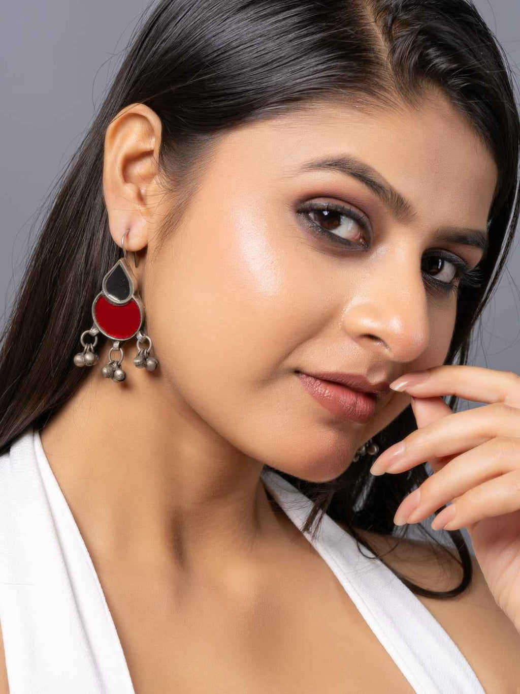 Afghani earrings featuring red and silver tones with intricate design and dangling bell charms