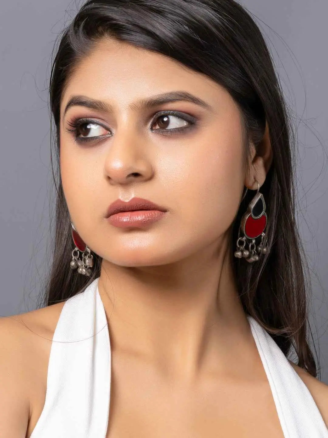 Traditional afghani earrings with red and green accents, featuring intricate silver details and dangling beads