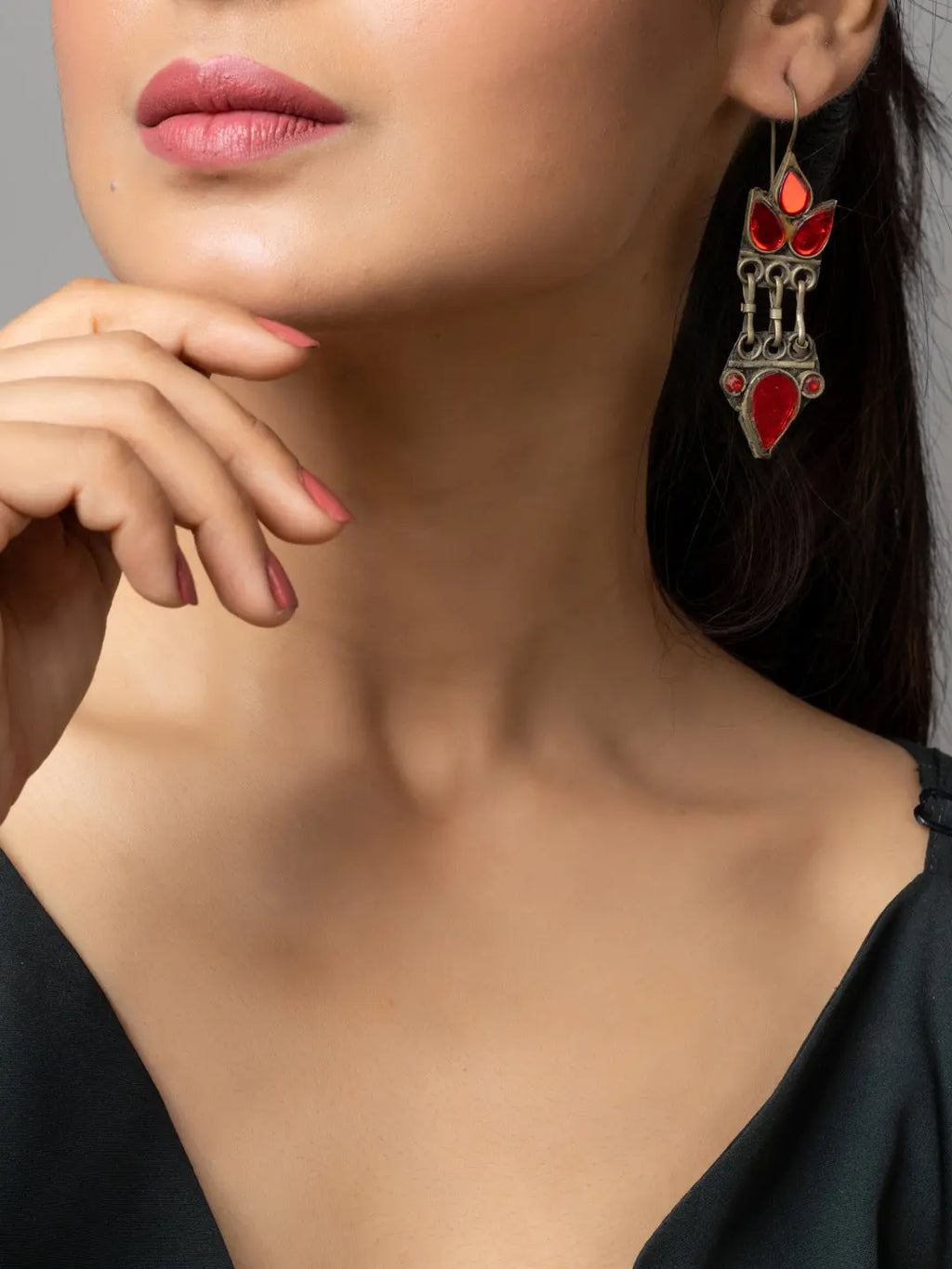 Close-up of woman wearing red and silver afghani earrings with intricate design from LOOK AND ADORN