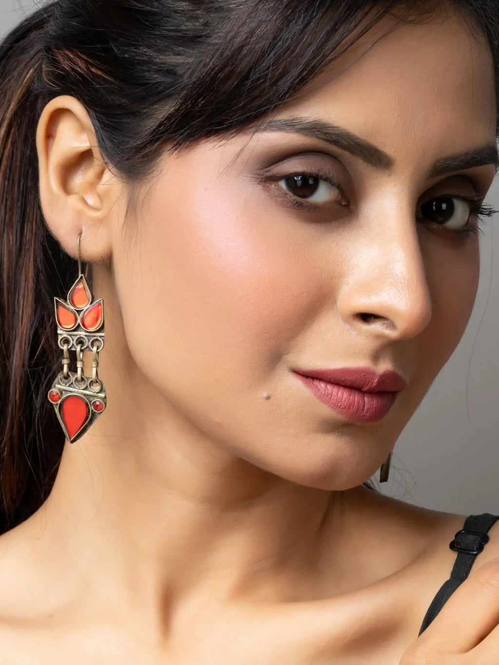Close-up of a woman wearing silver and red afghani earrings from LOOK AND ADORN Afghani Jewellery collection
