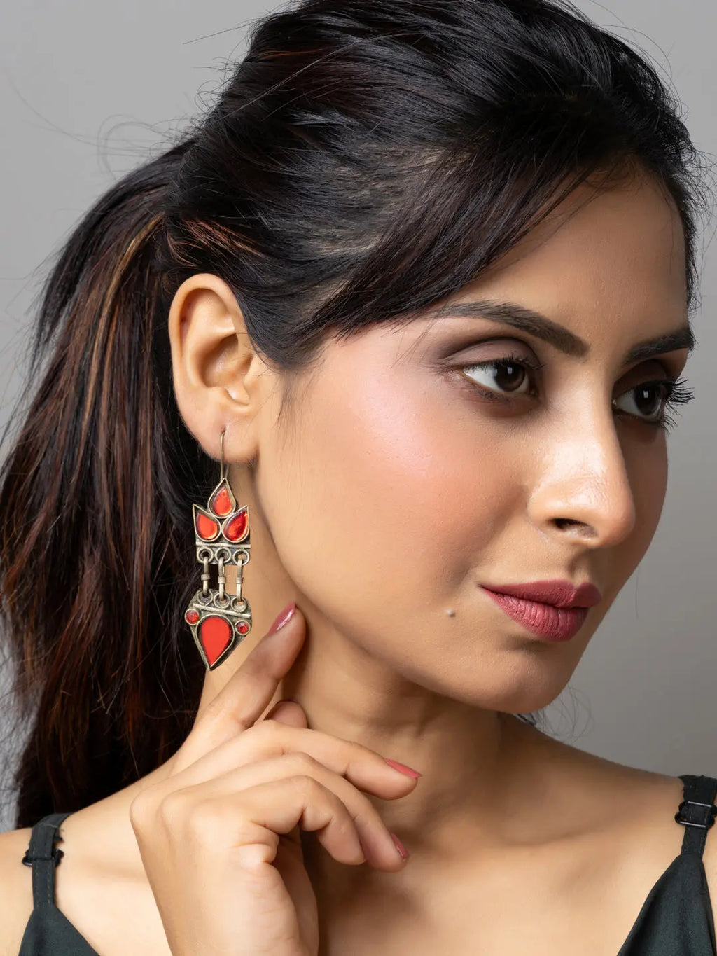 Close-up of woman wearing traditional red and silver afghani earrings from LOOK AND ADORN