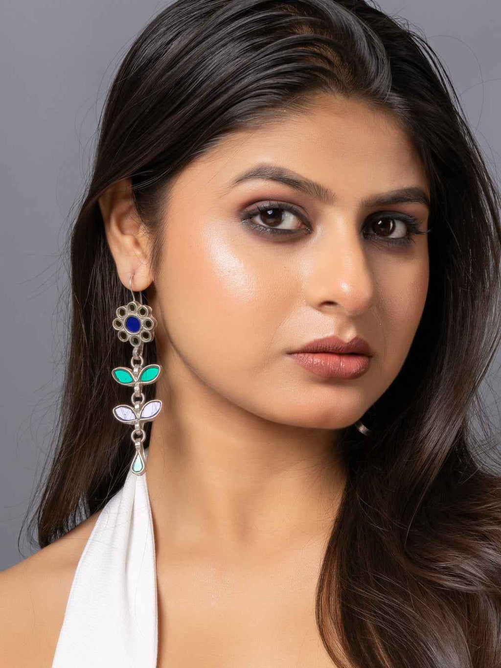 Afghani earrings featuring colorful gemstones and intricate floral design on silver metal