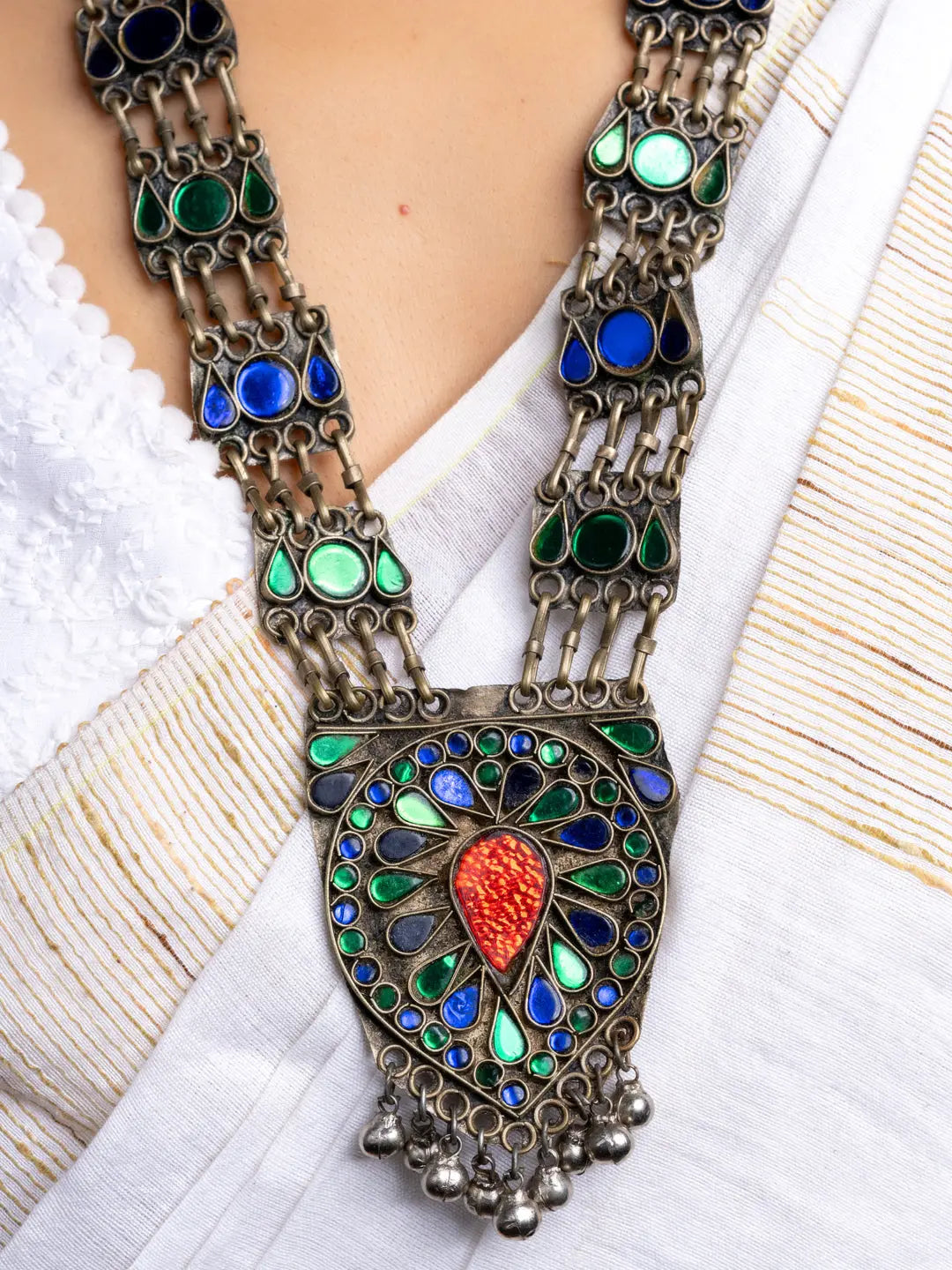 LOOK AND ADORN Afghani necklace with colorful stones and intricate metalwork on white fabric