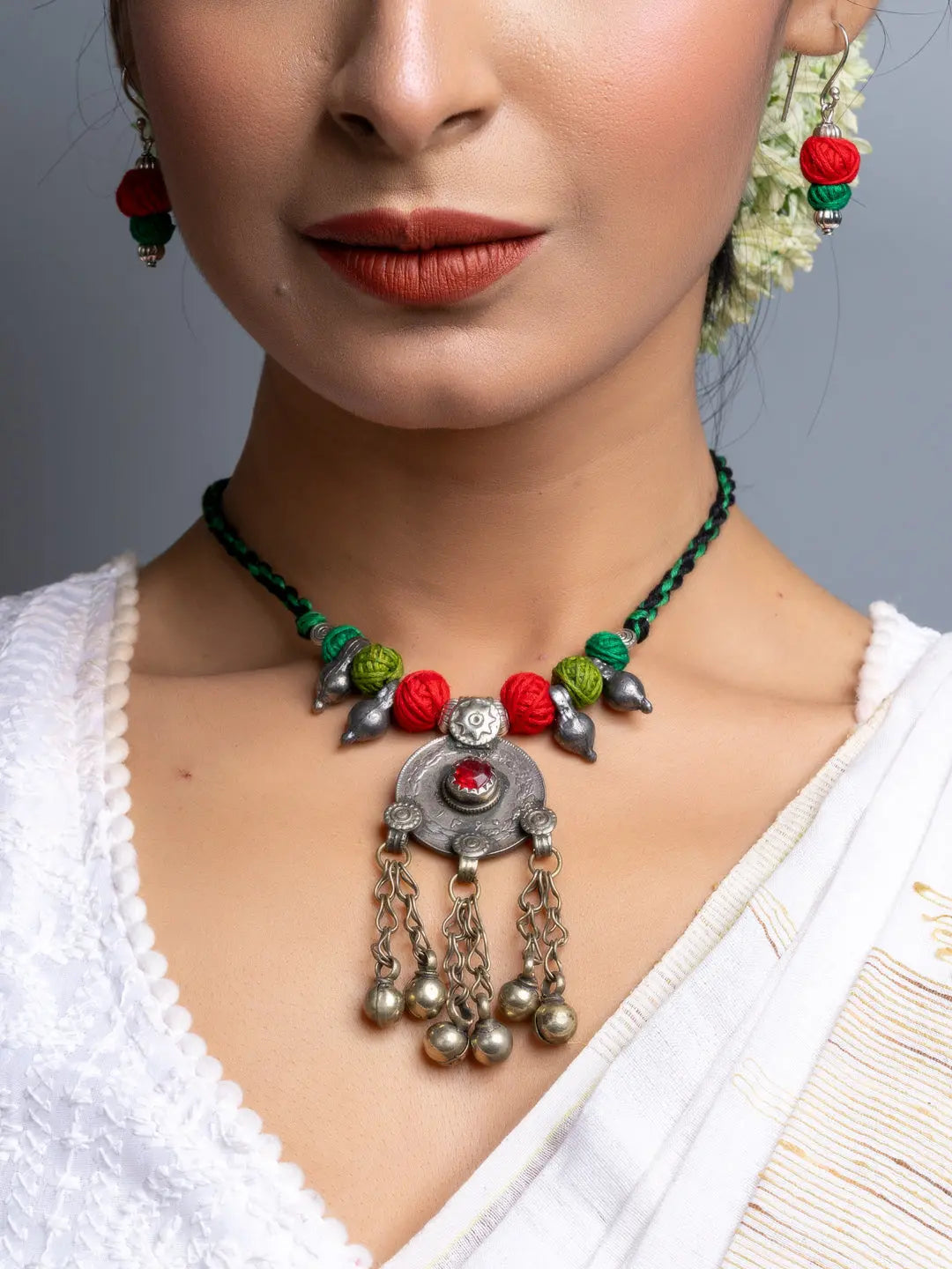 Traditional afghani necklace set with colorful beads and silver pendant worn with white attire