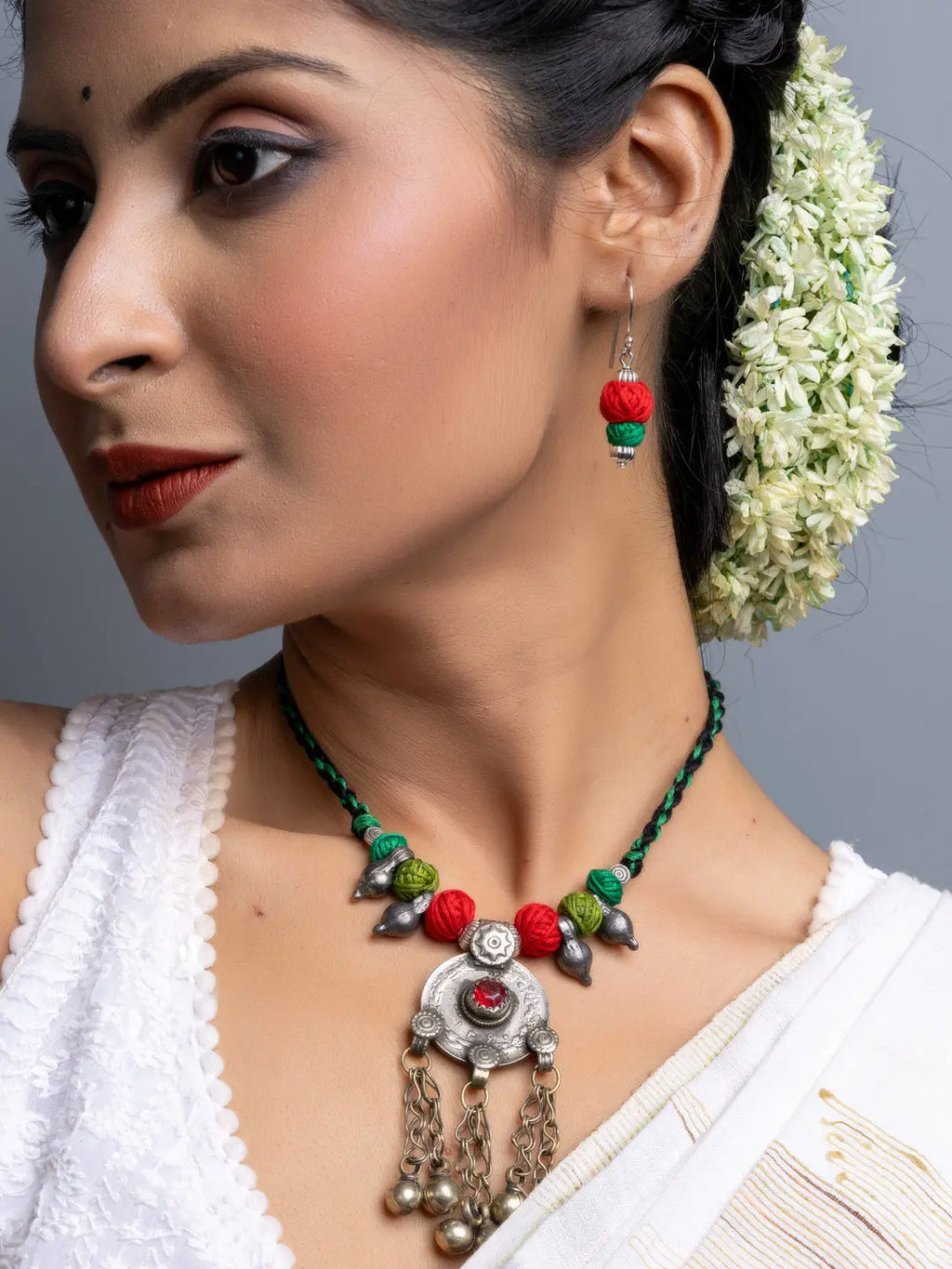 Woman wearing LOOK AND ADORN afghani necklace set with red and green beads and silver pendant with chains