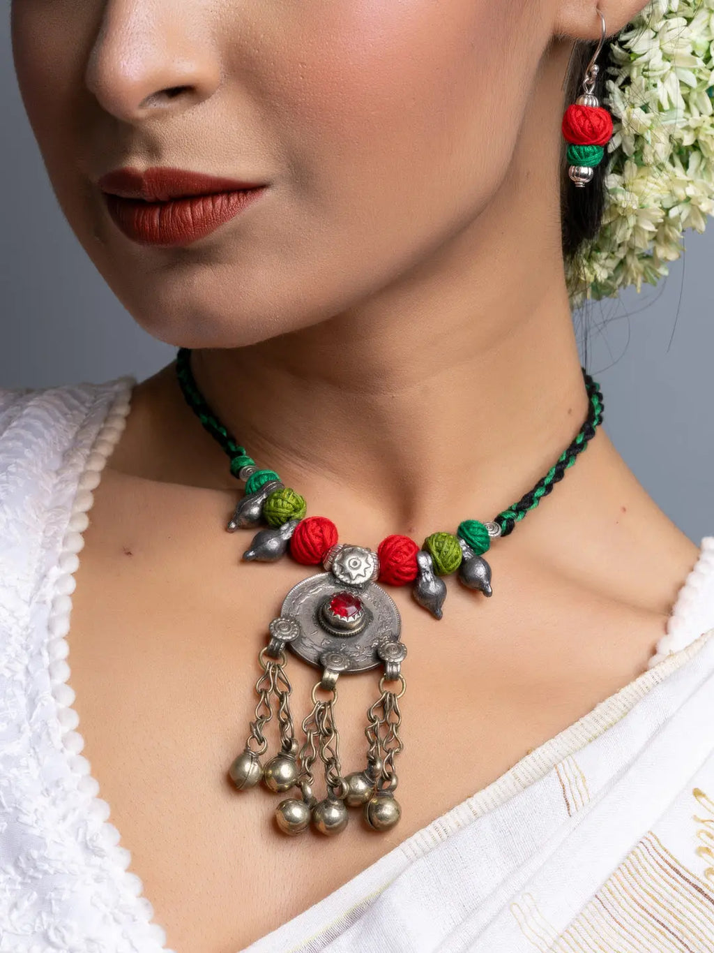 Afghani necklace set with intricate silver pendant and colorful beads worn with traditional attire