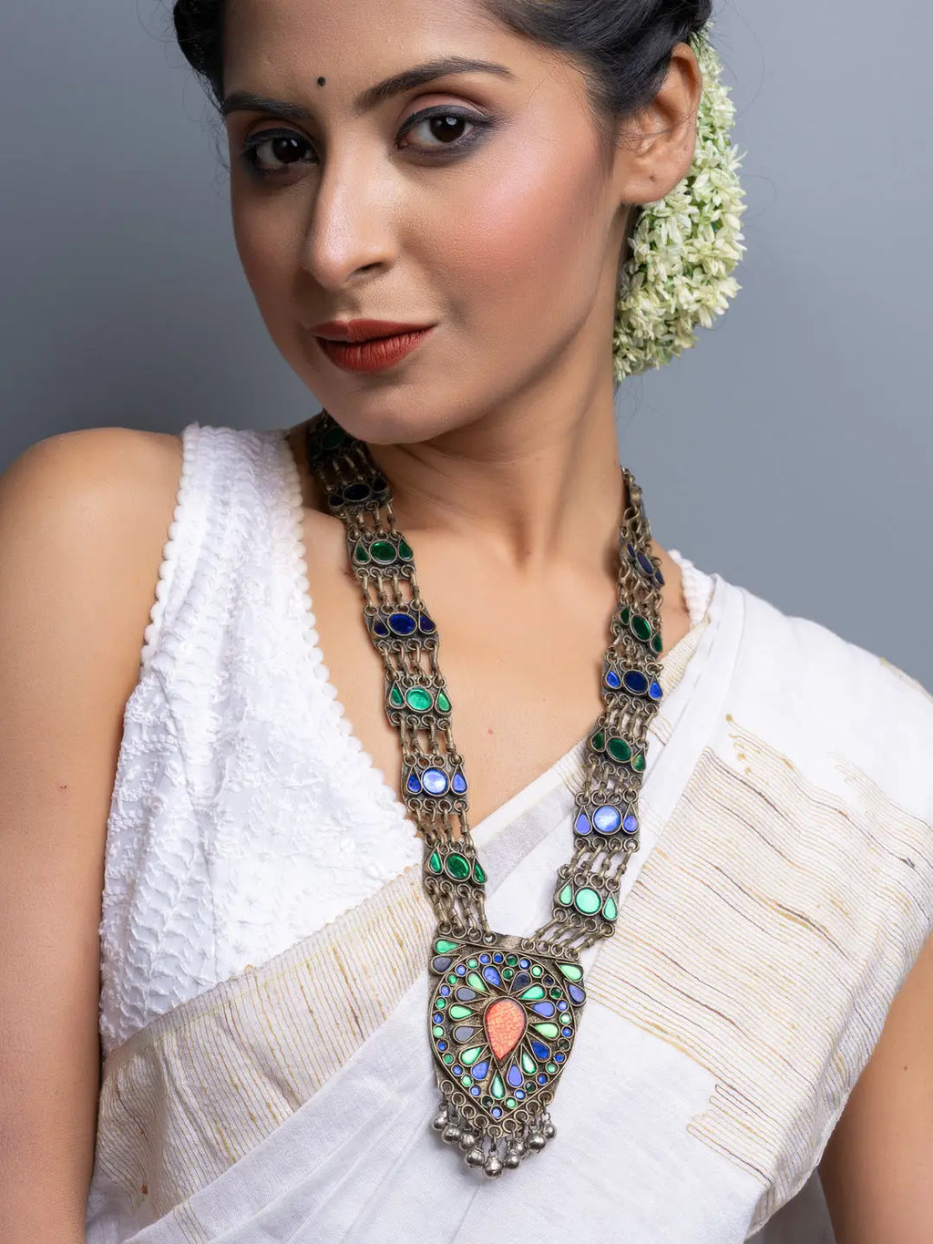 Woman wearing traditional Afghani necklace with colorful stones and intricate metalwork