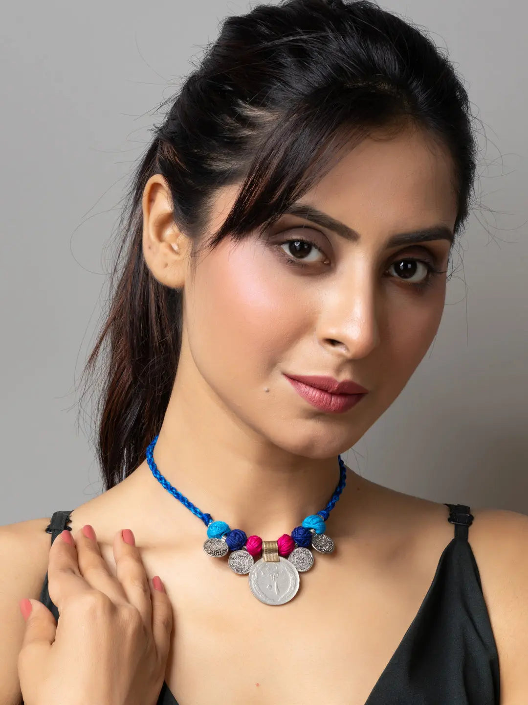 Woman wearing blue beaded Afghani pendant necklace with colorful beads and silver coin detail