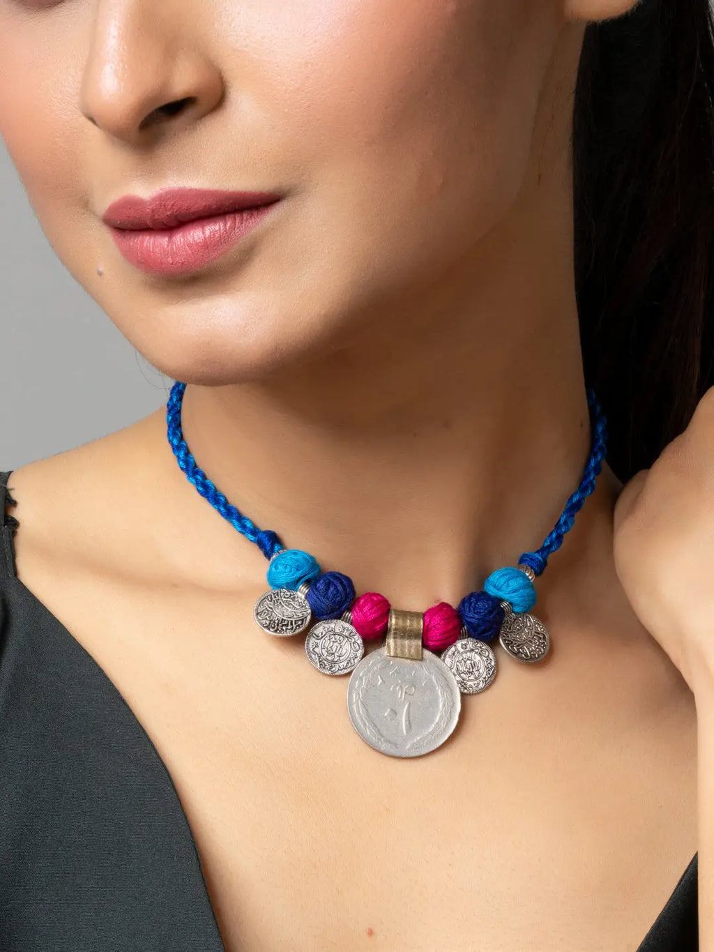 Afghani pendant necklace with colorful beads and silver coin charms worn by woman