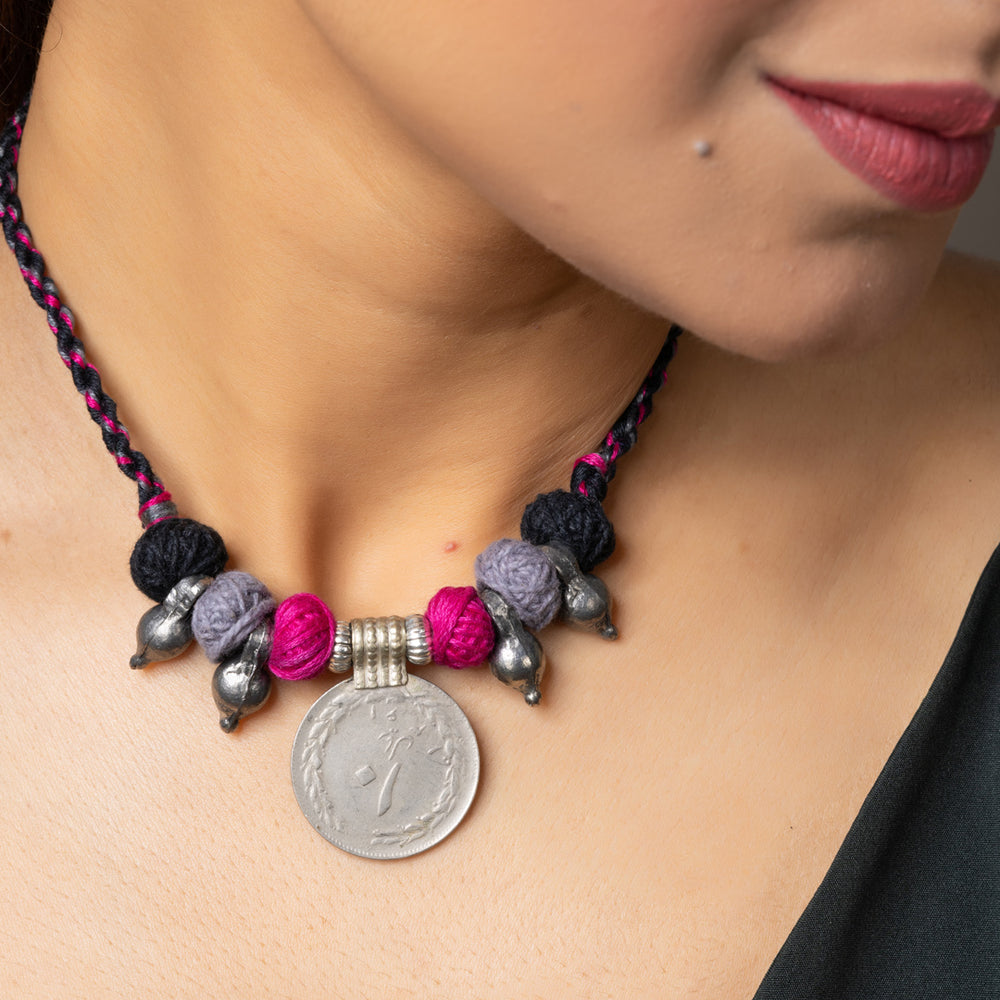 Close-up of woman wearing a handmade afghani pendant necklace with colorful beads and silver accents