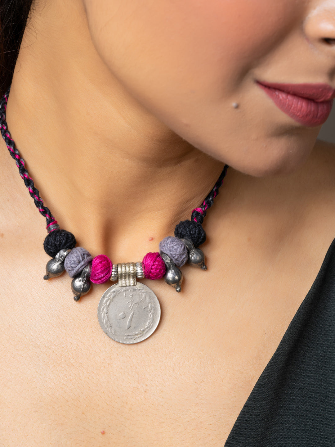 Close-up of woman wearing a handmade afghani pendant necklace with colorful beads and silver accents