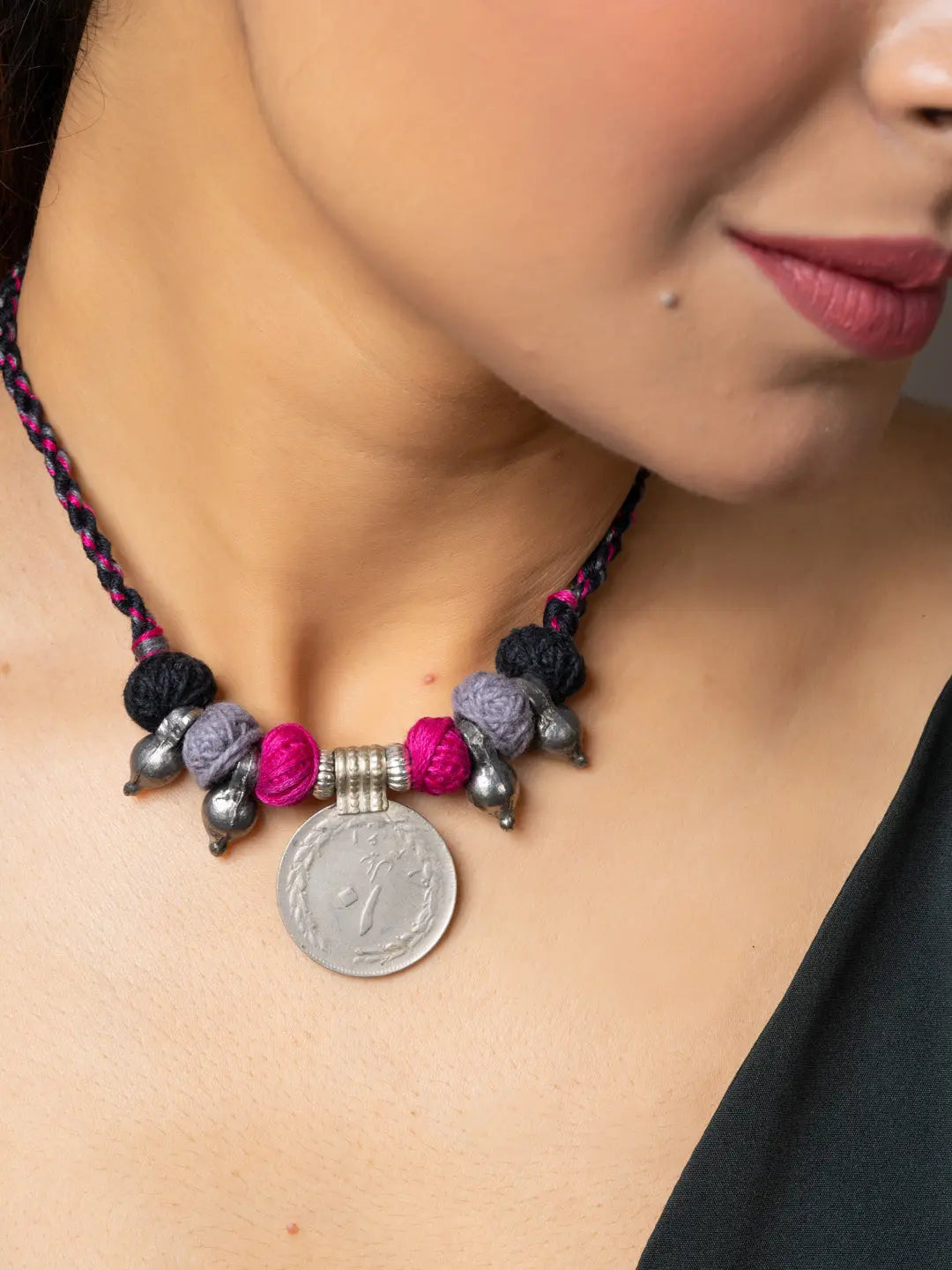Close-up of woman wearing a handmade afghani pendant necklace with colorful beads and silver accents