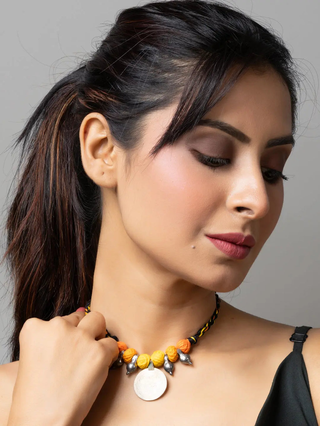 Woman wearing LOOK AND ADORN Afghani pendant necklace with yellow and orange beads and silver accents