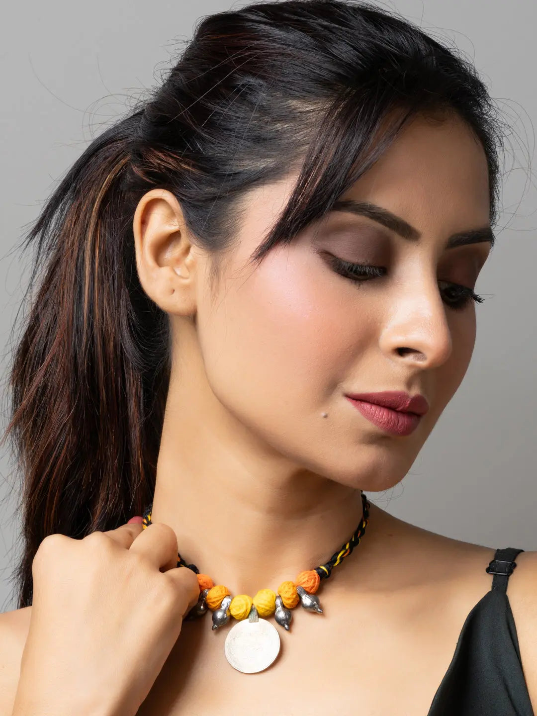 Woman wearing LOOK AND ADORN Afghani pendant necklace with yellow and orange beads and silver accents