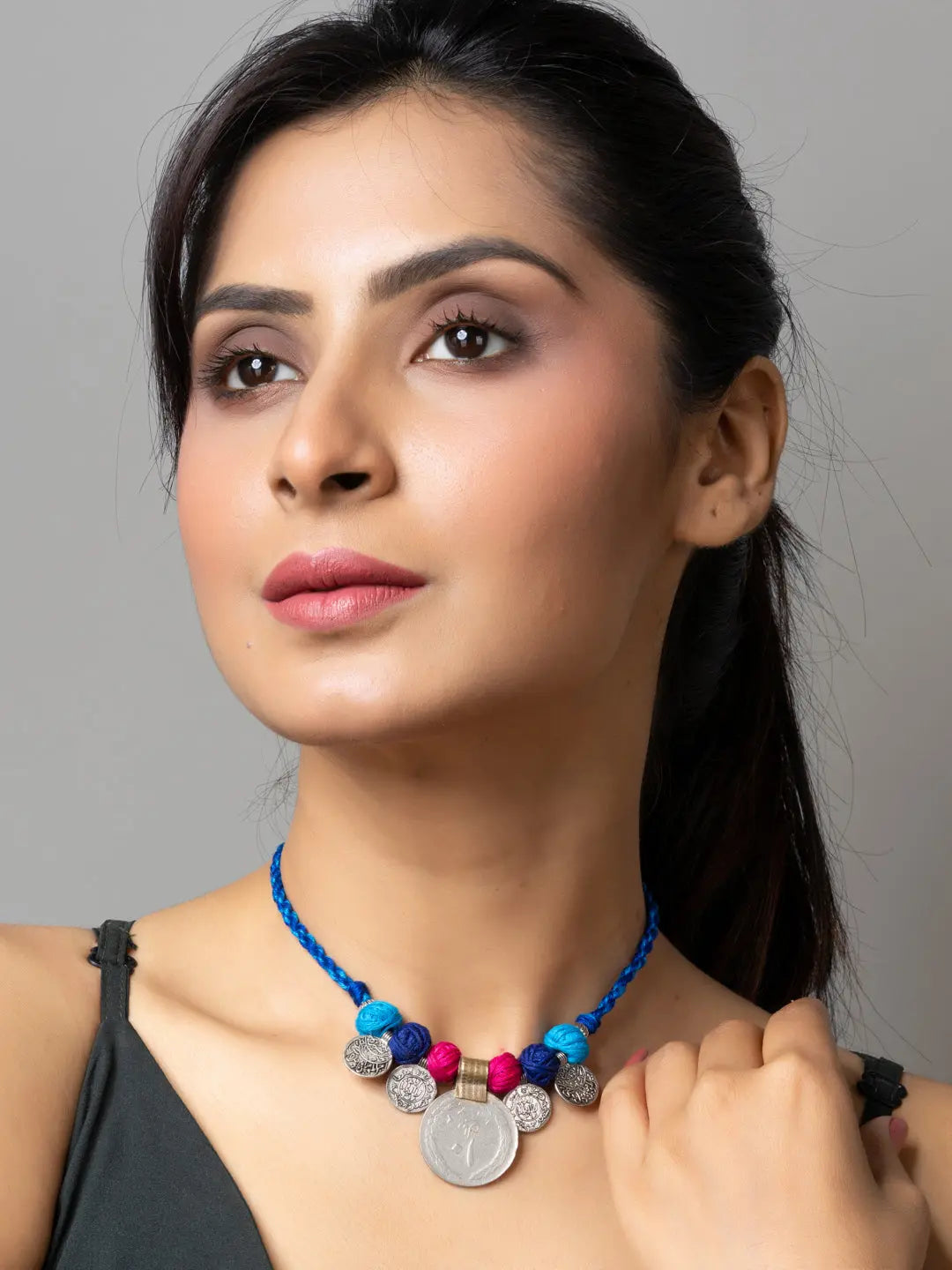 Woman wearing handcrafted colorful Afghani pendant necklace with silver coin and beads