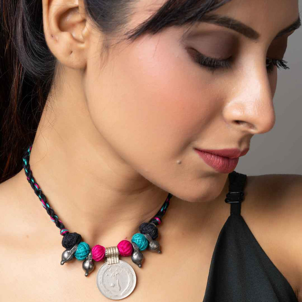 Woman wearing colorful Afghani pendant necklace with beads and coin on braided cord