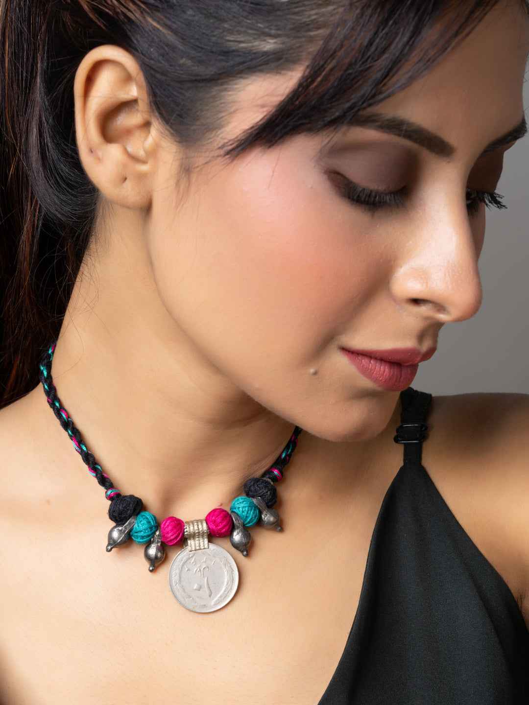 Woman wearing colorful Afghani pendant necklace with beads and coin on braided cord