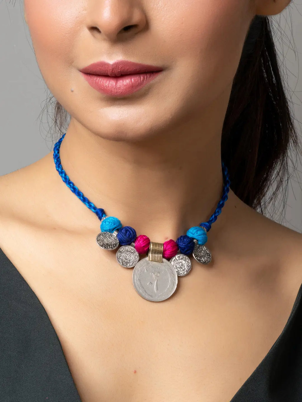 Afghani pendant necklace with colorful beads and silver coins worn by a woman