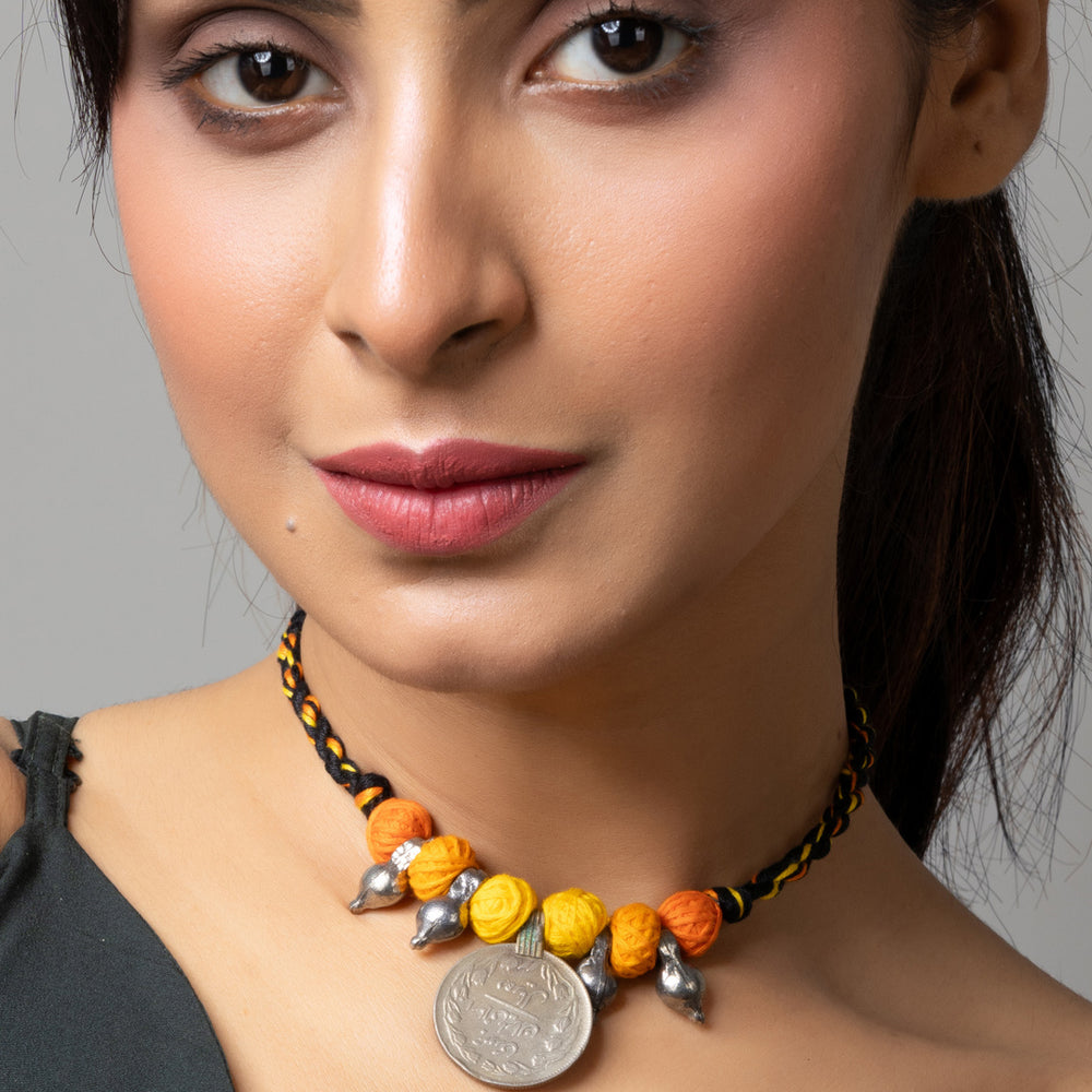 Close-up of woman wearing colorful afghani pendant necklace with yellow and orange beads