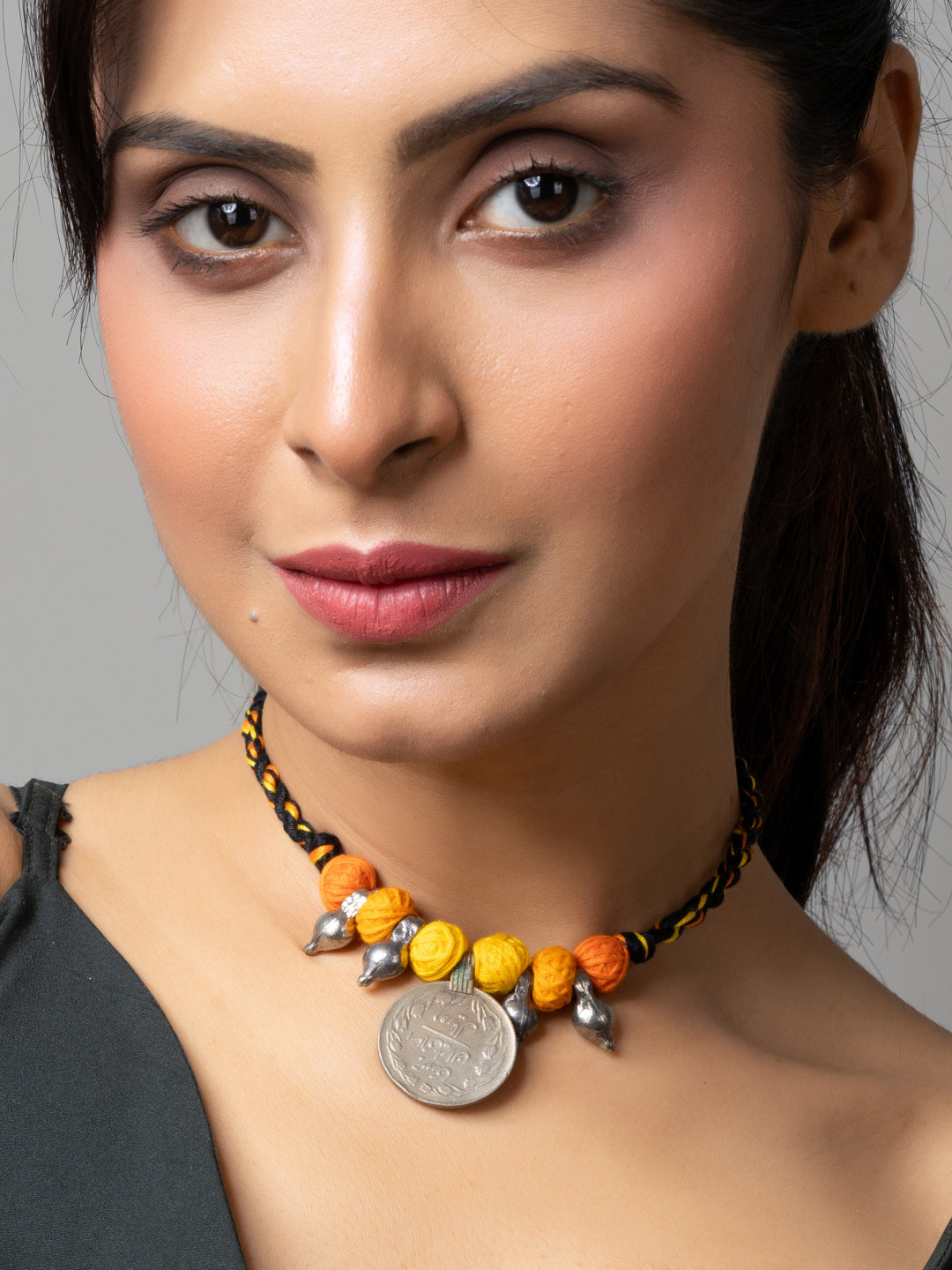 Close-up of woman wearing colorful afghani pendant necklace with yellow and orange beads