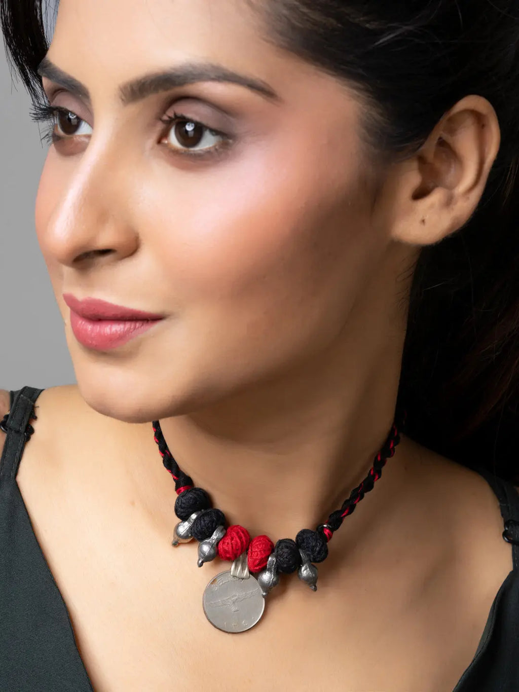 Woman wearing a handcrafted Afghani pendant necklace with red and black beads and silver accents