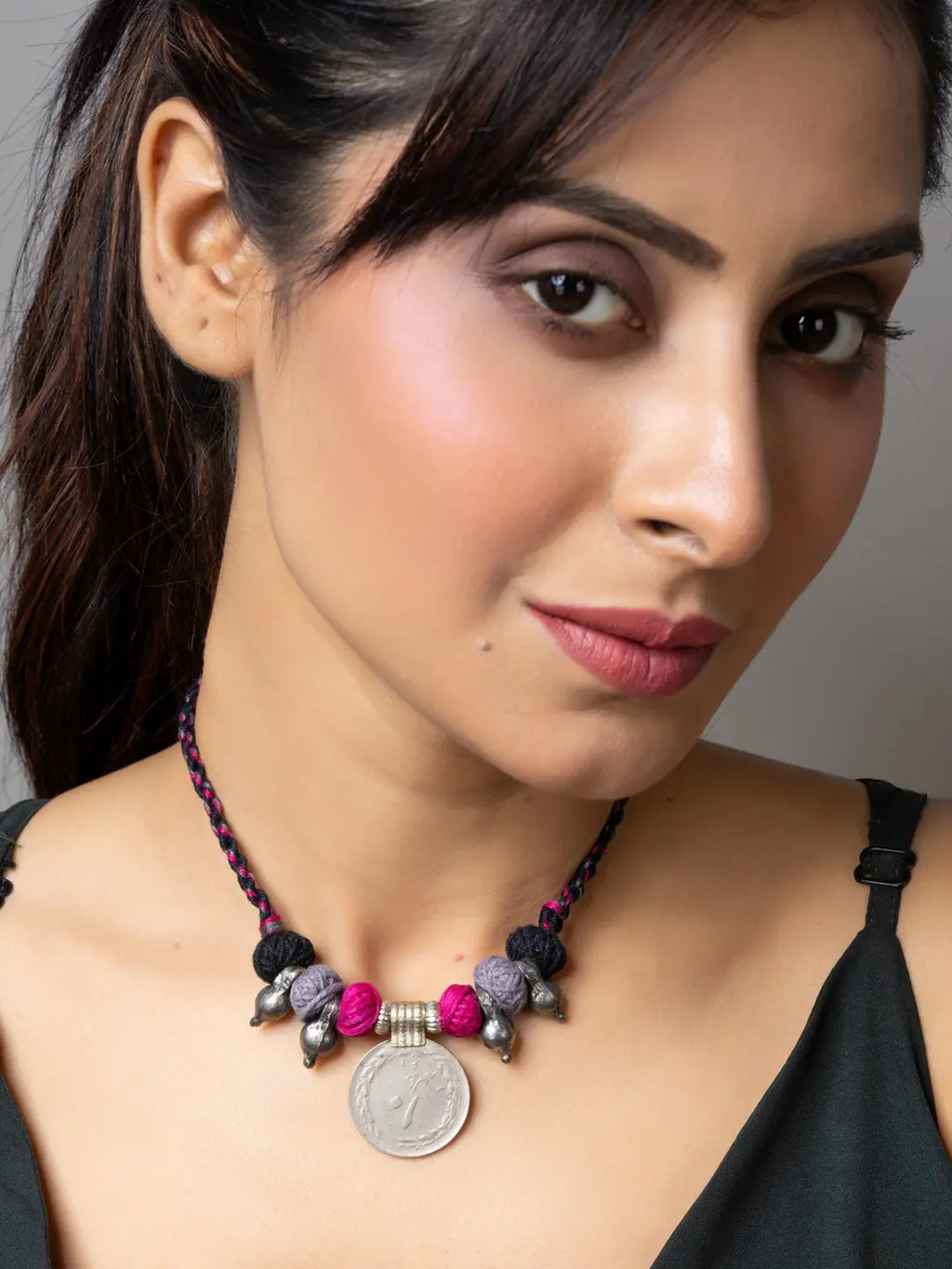 Close-up of woman wearing LOOK AND ADORN Afghani pendant necklace with colorful beads and coin charm