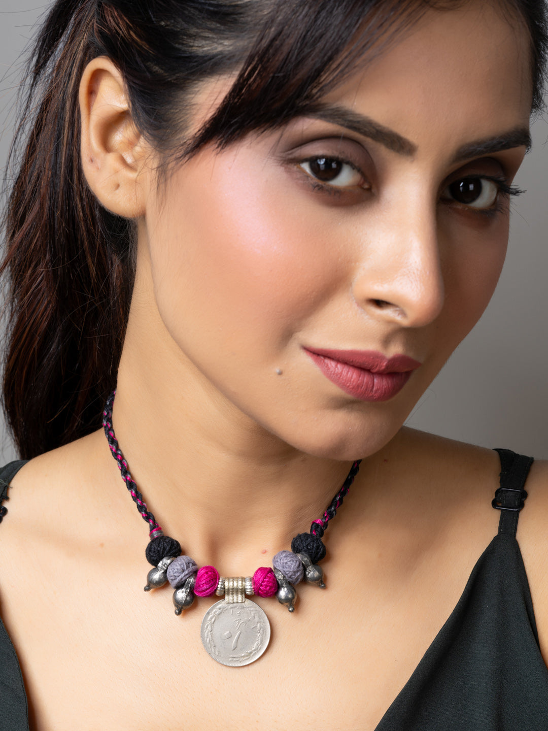 Close-up of woman wearing LOOK AND ADORN Afghani pendant necklace with colorful beads and coin charm