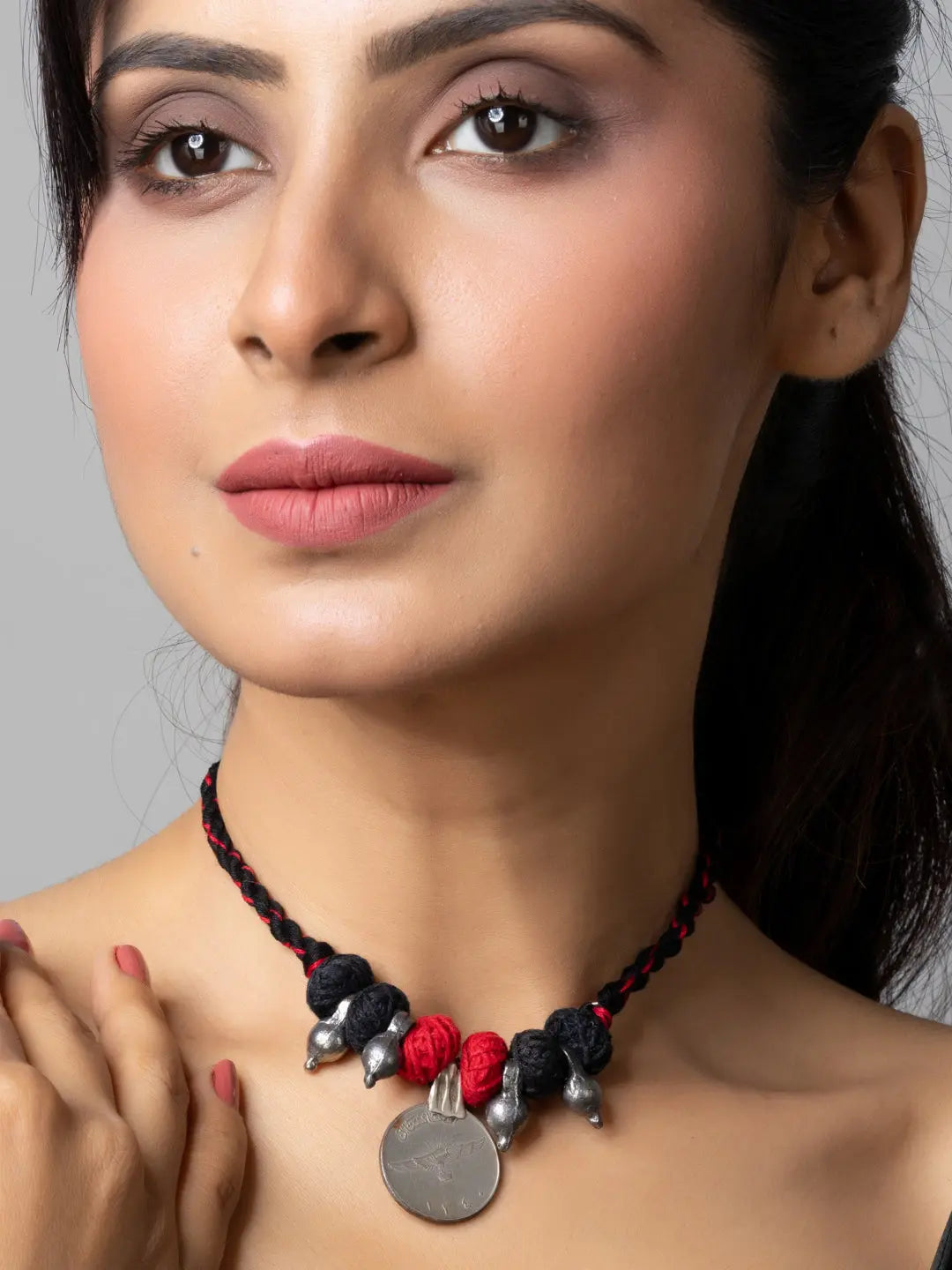 Close-up of woman wearing a black and red afghani pendant necklace from LOOK AND ADORN