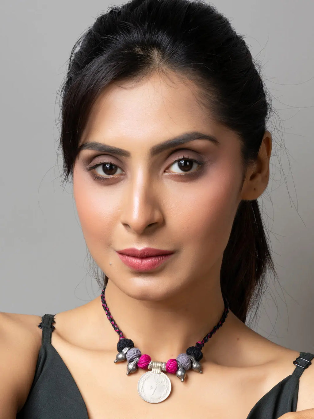 Woman wearing a handmade afghani pendant necklace with colorful beads and intricate design