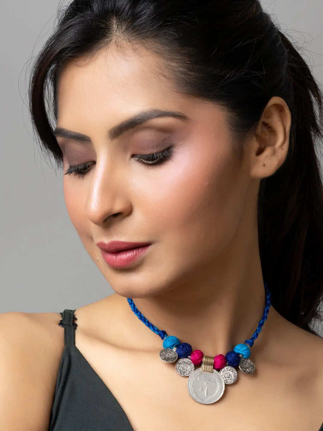 Woman wearing a colorful afghani pendant necklace with blue beads and silver accents