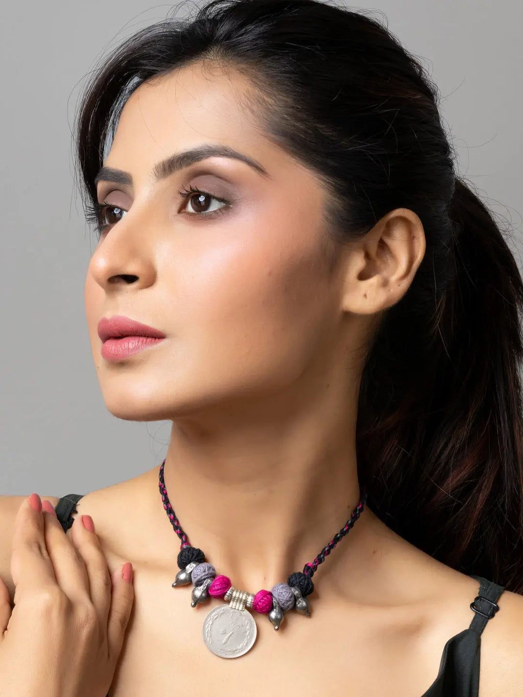 Woman wearing a colorful afghani pendant necklace with silver and pink beads by LOOK AND ADORN