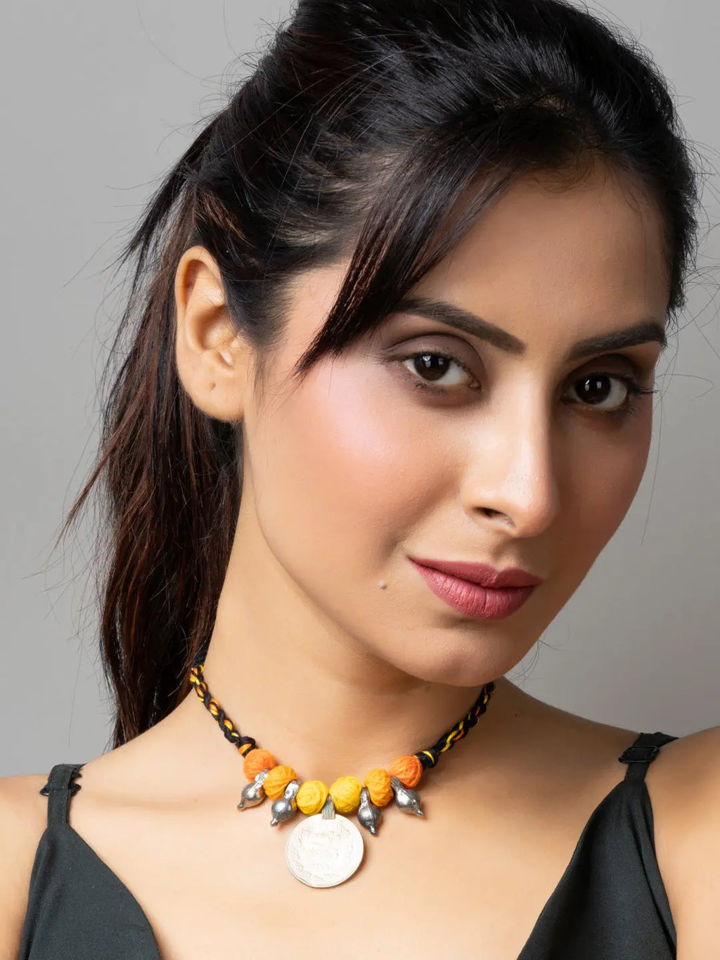 Woman wearing an Afghani pendant necklace with orange beads and silver charms from LOOK AND ADORN