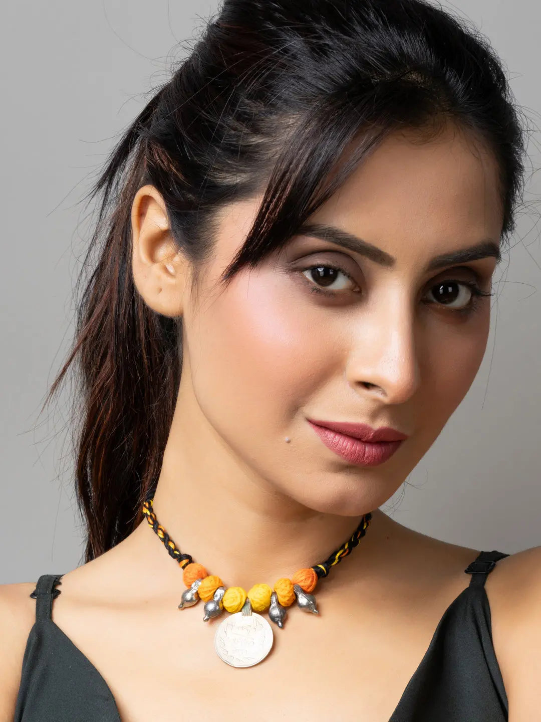 Woman wearing an Afghani pendant necklace with orange beads and silver charms from LOOK AND ADORN
