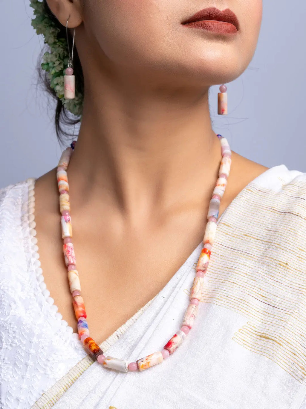 Handmade agate necklace with matching earrings featuring multicolor stone beads worn by woman