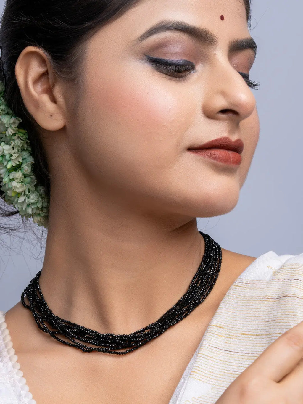 Handmade black crystal necklace by LOOK AND ADORN worn on woman with elegant makeup and traditional attire