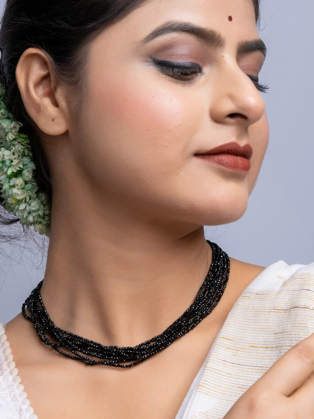 Handmade black crystal necklace by LOOK AND ADORN worn on woman with elegant makeup and traditional attire