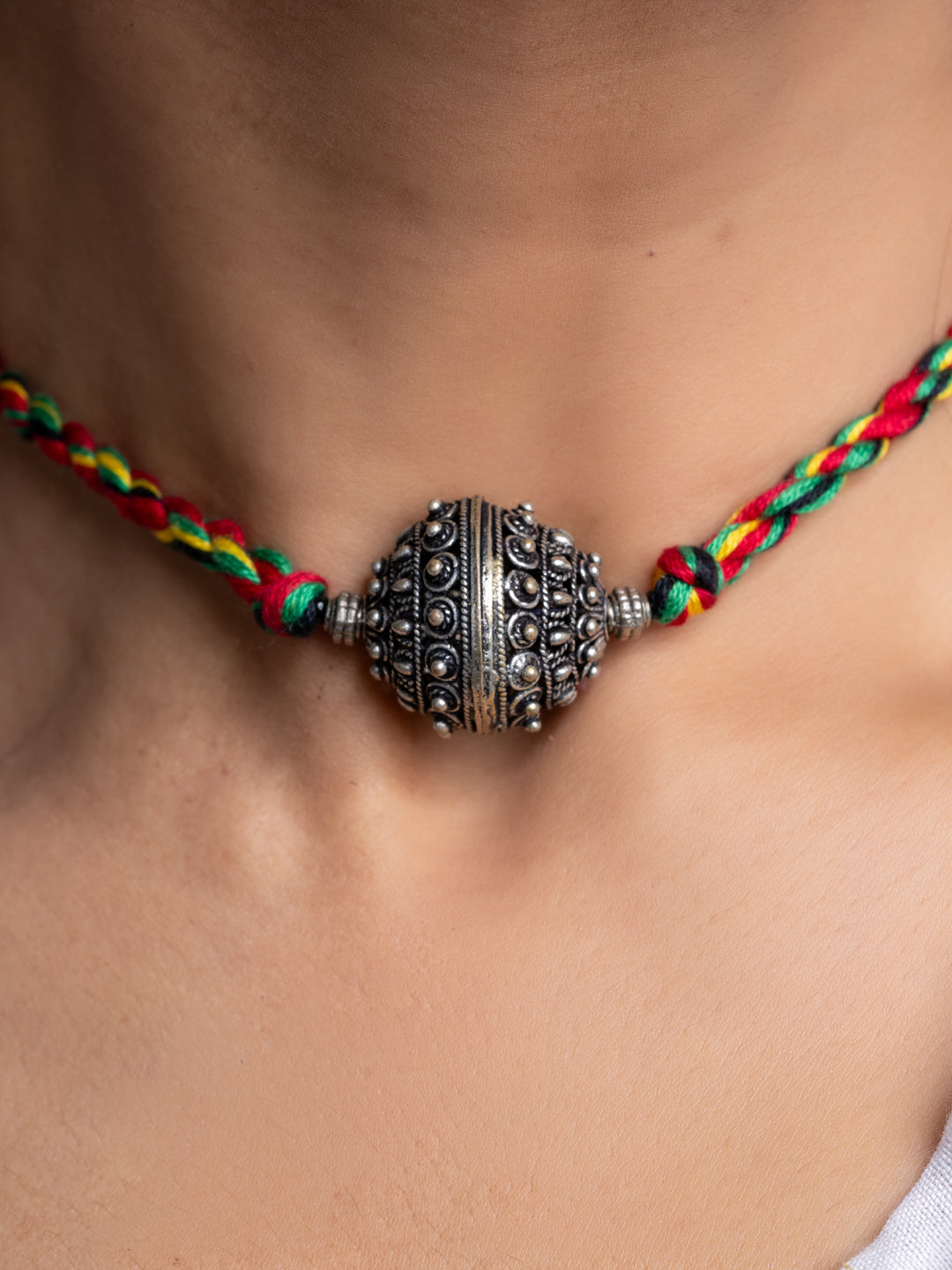 Handmade german silver choker necklace with detailed spherical pendant on colorful braided cord