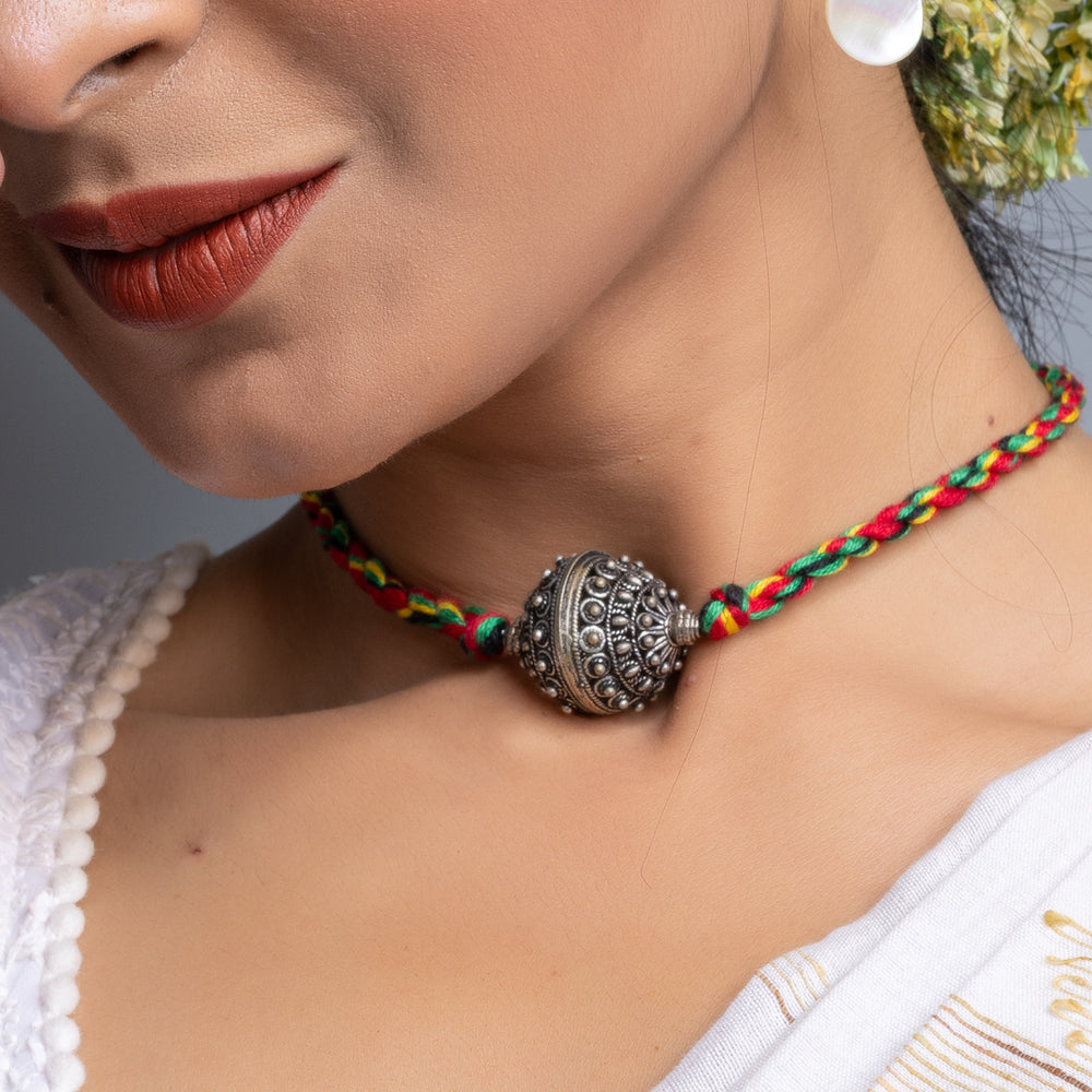 Handmade german silver choker necklace with intricate pendant on colorful braided cord worn by woman