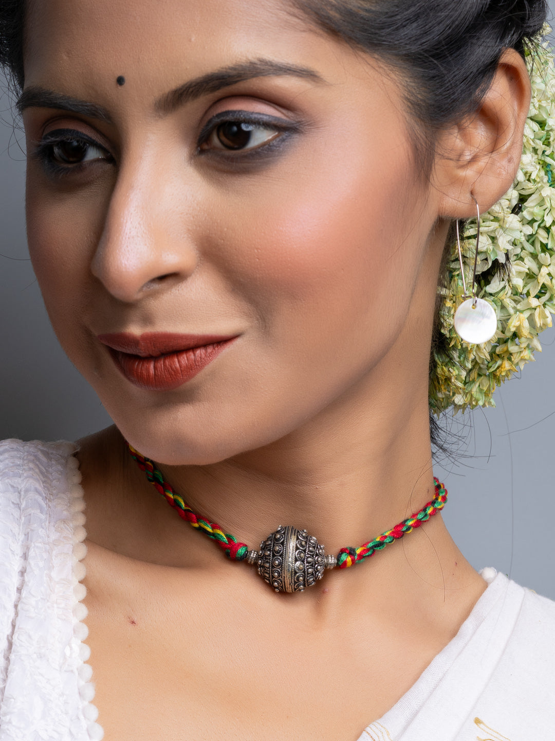 Handmade german silver choker necklace with intricate central pendant on woman wearing white top