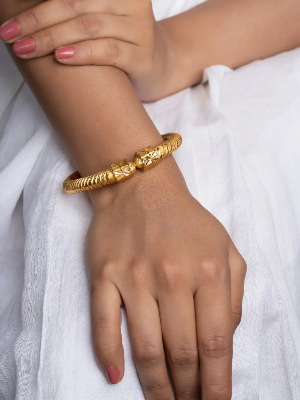 LOOK AND ADORN gold plate bangle on a female wrist ornate textured design on white dress