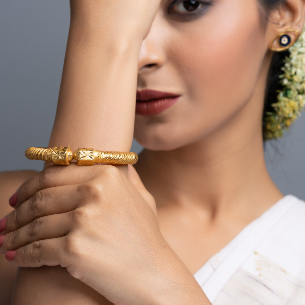 LOOK AND ADORN gold plate bangle showcased on a model wearing a white saree with jasmine hair