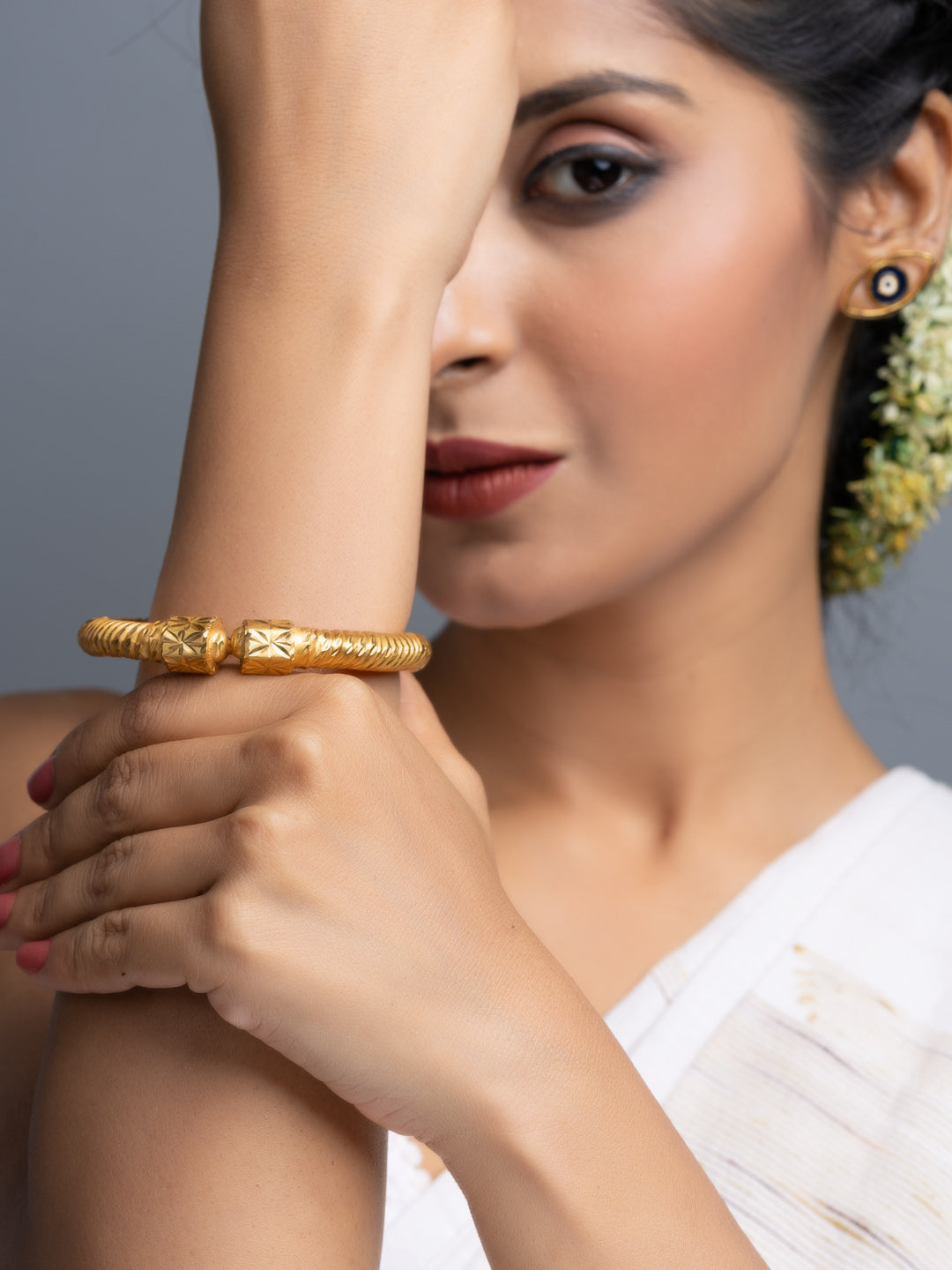 LOOK AND ADORN gold plate bangle showcased on a model wearing a white saree with jasmine hair