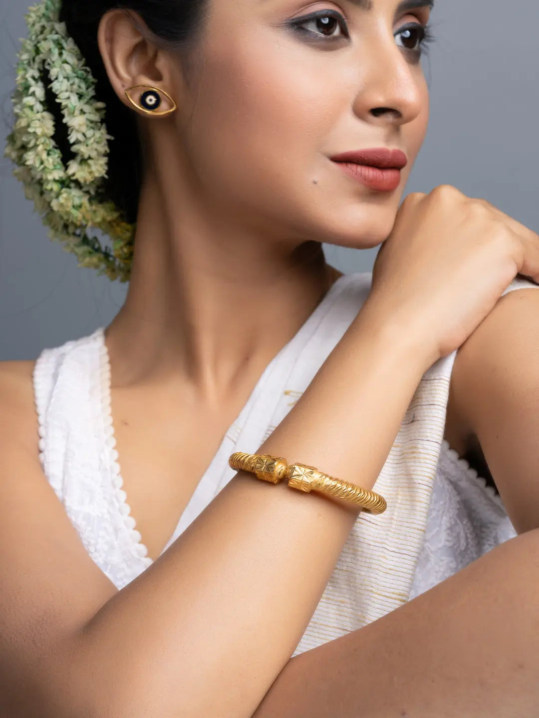 LOOK AND ADORN gold plate bangle on model wrist paired with jasmine hair garland and gold stud earrings