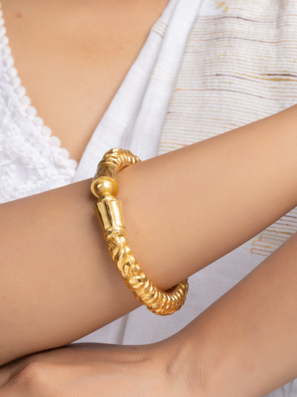 LOOK AND ADORN gold plated bangle rope twist design with decorative end caps on model wrist