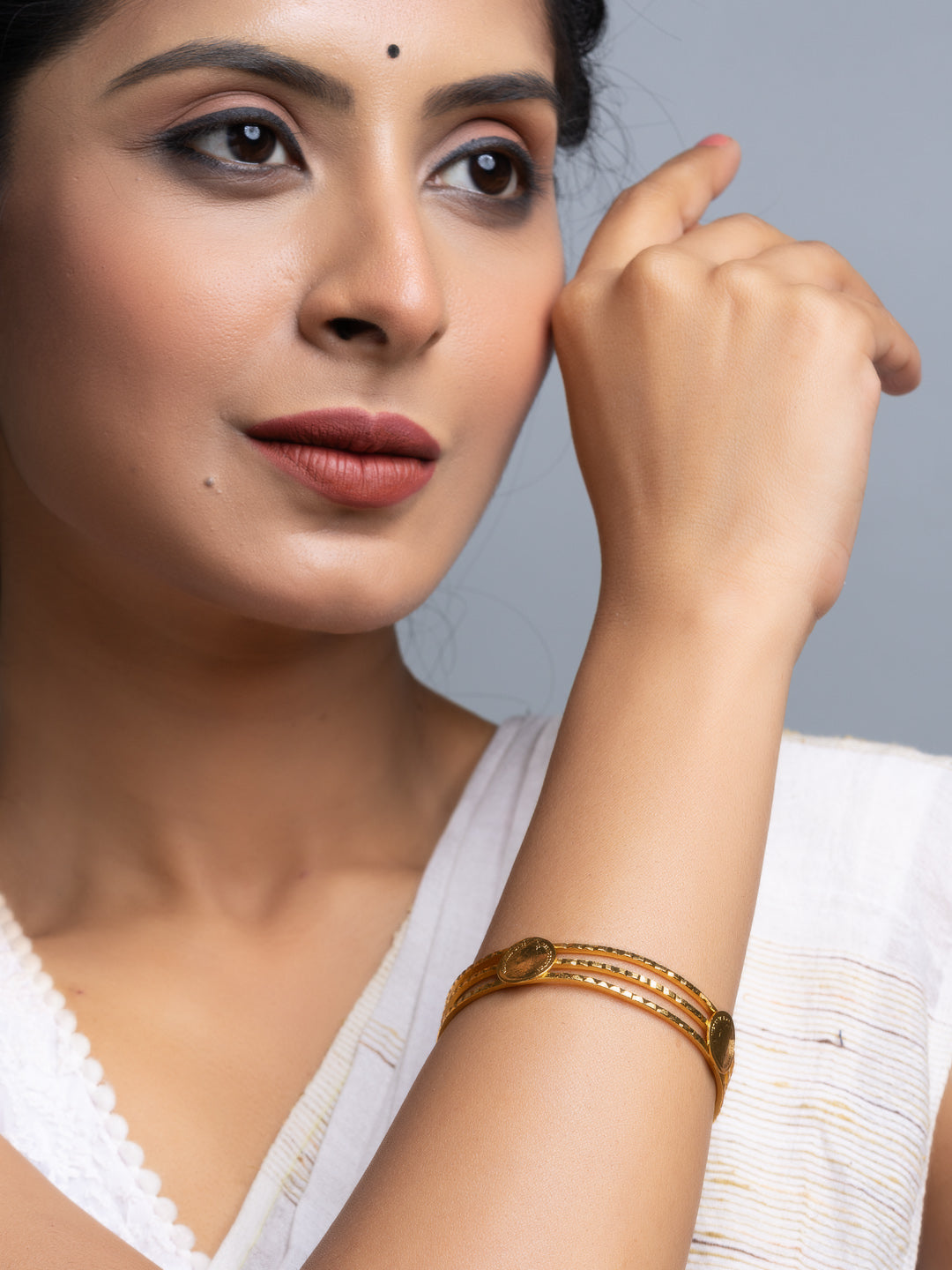 LOOK AND ADORN model wearing a gold plated bangle double row with medallion accents on wrist